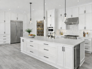 Spacious white kitchen remodeling in Tampa Bay with large island, shaker cabinets, stainless appliances, and modern pendant lighting.