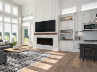 Full-home remodeling project in Tampa Bay featuring open living room with expansive windows, fireplace wall, and integrated kitchen layout